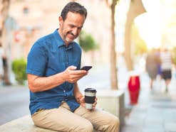 Mann mit Kaffee und Smartphone
