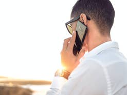 Mann telefoniert mit einem Smartphone im Sonnenlicht