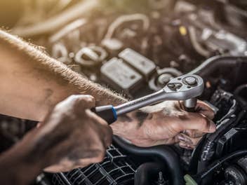 Mechaniker arbeitet im Motorraum eines Autos.