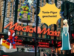 Eine MediaMarkt-Filiale mit Weihnachtsdekoration im Hintergrund. Daneben Tonie-Figuren, welche es aktuell geschenkt gibt.