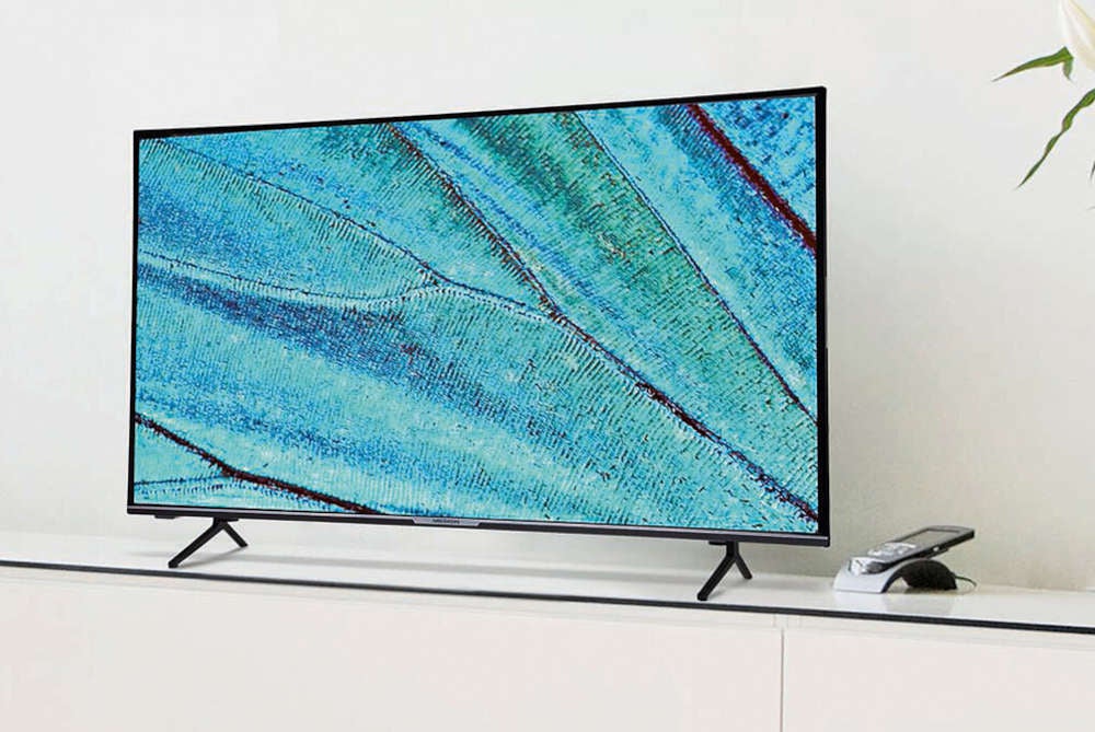 MEDION LIFE Ultra HD LCD Smart-TV X15811, 146,1 cm (58") steht auf einer Kommode.