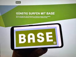 Base-Logo auf einem Smartphone vor der Base-Homepage.