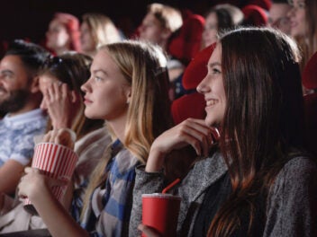Junge Frauen und Männer schauen sich im Kino einen Film an.
