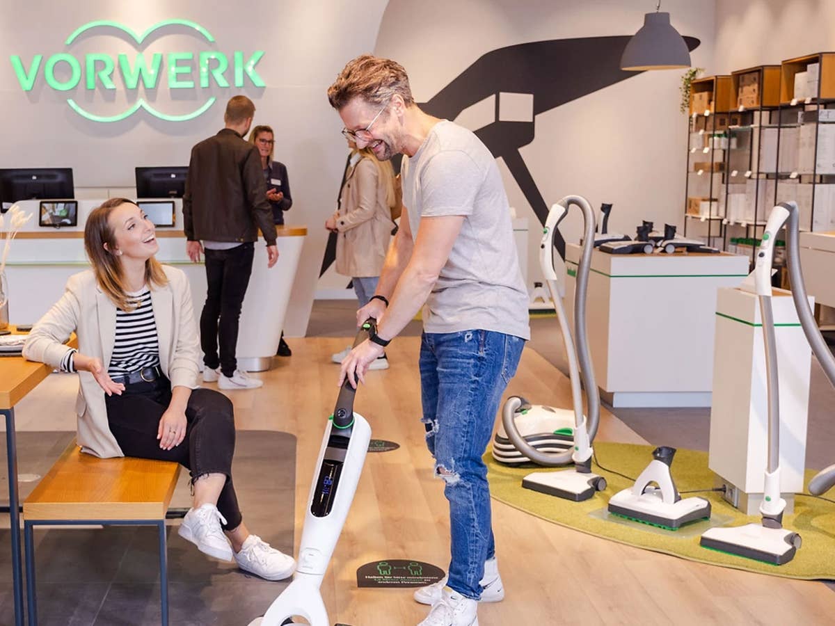 Menschen probieren Staubsauger in einem Vorwerk Store aus