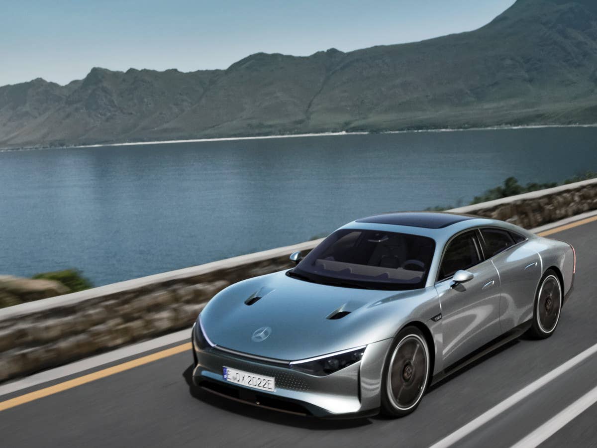 Mercedes-Benz Vision EQXX fährt auf einer Straße vor einem See mit Bergkulisse.