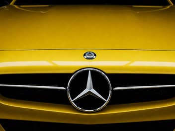 Mercedes-Logo an der Front eines Autos.