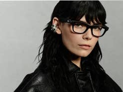 Eine Frau mit dunklen Haaren und Lederjacke trägt die neue schwarze Ray-Ban Meta Blayzer Smartglass.