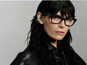 Eine Frau mit dunklen Haaren und Lederjacke trägt die neue schwarze Ray-Ban Meta Blayzer Smartglass.