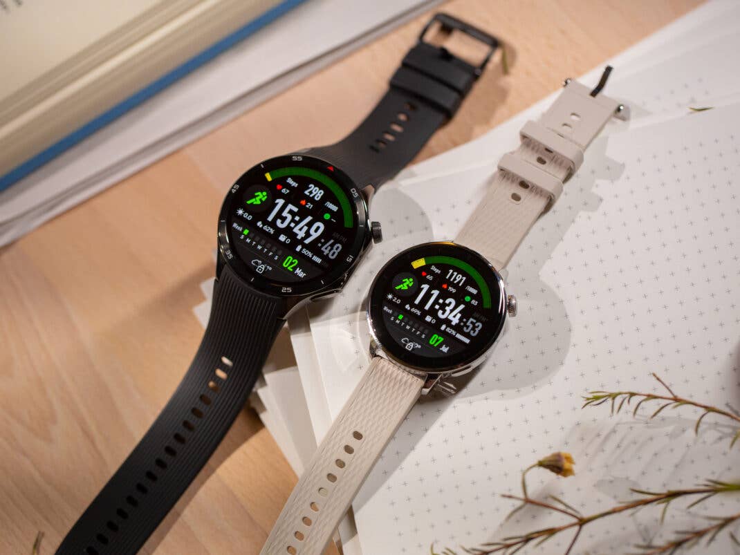 Zwei Handgelenke mit der OnePlus Watch 3, die lebendige Anzeigen mit Fitnessstatistiken zeigen.