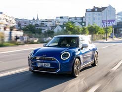 Mini Cooper SE Frontansicht während der Fahrt auf der Straße.