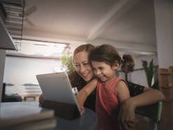 Frau mit Kind nutzt einen Tablet PC.