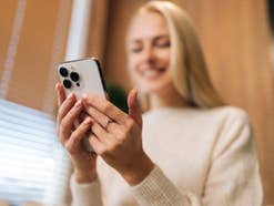 Eine junge Frau hält ein Handy in der Hand