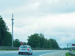 Ein Mobilfunk-Sendemast steht an einer Autobahn