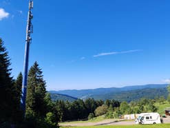 Ein Wohnmobil steht unter einer Mobilfunkantenne im Schwarzwald