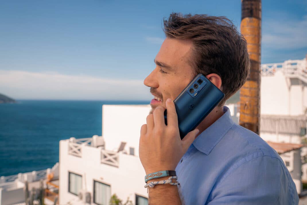 Das Motorola Edge 20 Pro Smartphone in der Hand eines Mannes, der telefonierend vor dem Meer steht