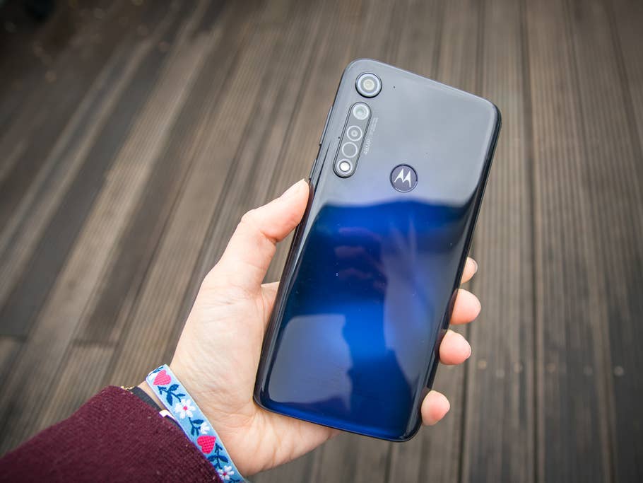 Das Moto G8 Plus von hinten zu sehen, die blaue Rückseite spiegelt das Licht, in einer Hand gehalten.