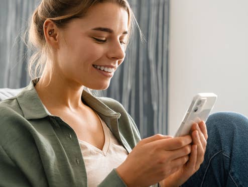 Nahaufnahme einer Frau wie sie auf ihr Smartphone schaut