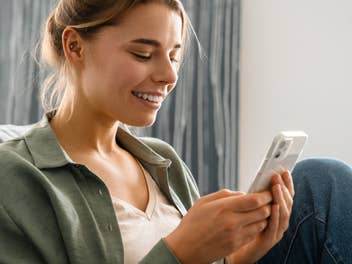 Nahaufnahme einer Frau wie sie auf ihr Smartphone schaut