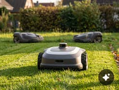 Drei Mähroboter auf einem Rasen