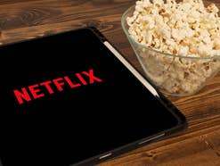 Netflix auf einem Tablet PC neben einer Popcorn-Schale.