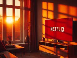 Netflix-Logo auf einem Fernseher im Licht eines Sonnenuntergangs.