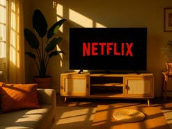Netflix-Logo auf einem Fernseher in einem sommerlichen Wohnzimmer.