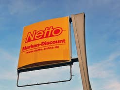 Netto Logo von einer Filiale vor einem blauen Himmel