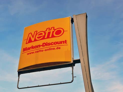 Netto Logo von einer Filiale vor einem blauen Himmel