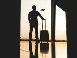 Mann mit Handgepäck am Flughafen