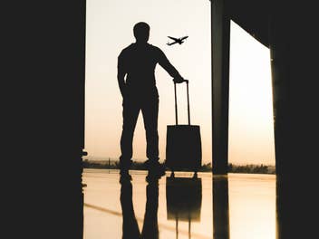 Mann mit Handgepäck am Flughafen
