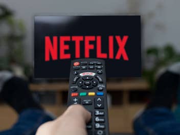 Netflix-Logo auf einem Fernseher mit Fernbedienung im Vordergrund.