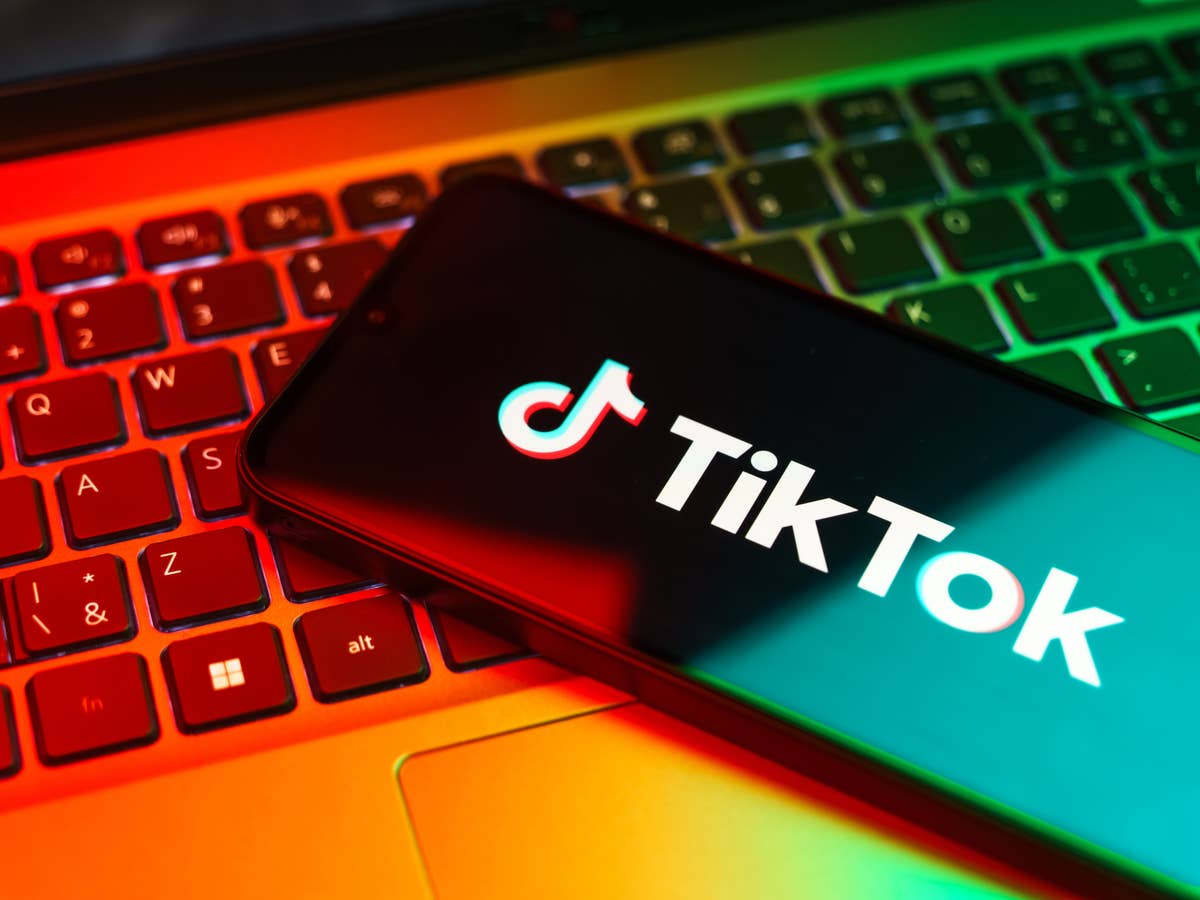 Neue Regeln: Große Apps vor radikaler Änderung App von TikTok auf einem Smartphone, das auf einer Notebook-Tastatur liegt.