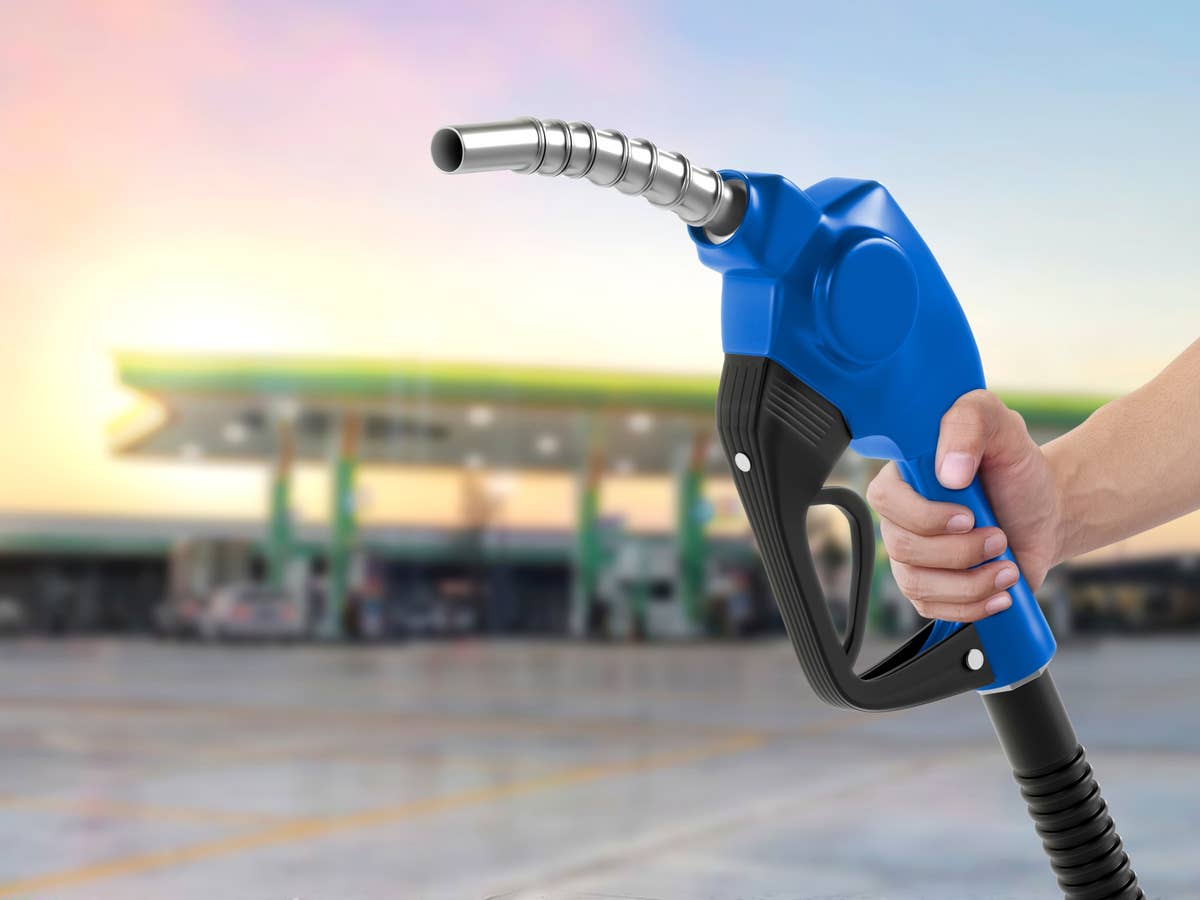 Zapfhahn einer Tankstelle in der Hand einer Frau.