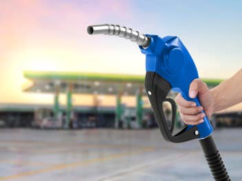 Zapfhahn einer Tankstelle in der Hand einer Frau.