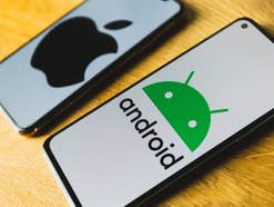 iPhone und Android-Smartphone mit den Logos von Apple und Android im Display.