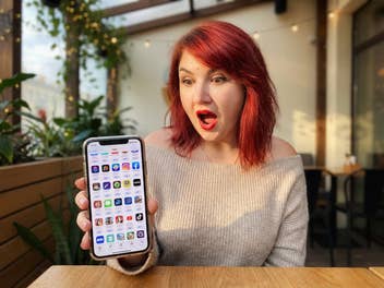 Eine Frau sieht erstaunt auf ihr Handy, wo viele kostenlose Apps angeboten werden.