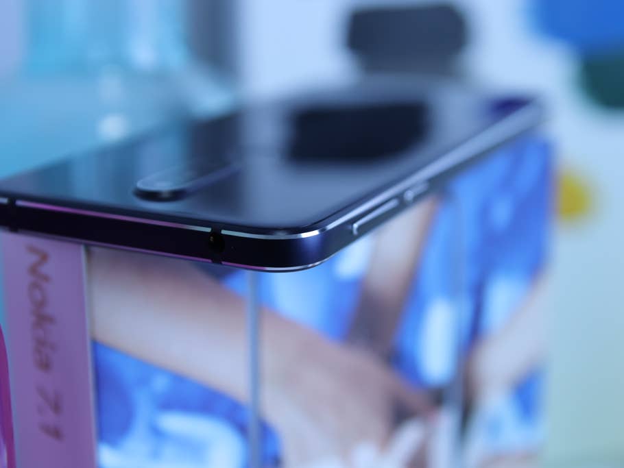 Handy Nokia 7.1 auf einem Tisch mit Gläsern im Hintergrund