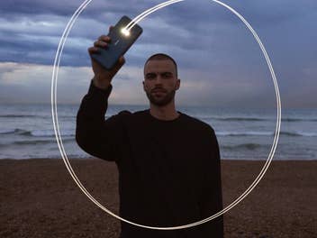 Man steht mit einem Nokia-Smartphone am Strand und zeichnet einen Lichtkreis in die Luft.