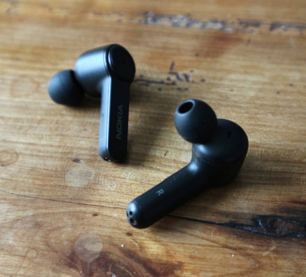 Die Nokia Noise Cancelling Earbuds einzeln auf einem Holztisch.