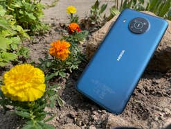Nokia X20 liegt im Beet mit Blumen