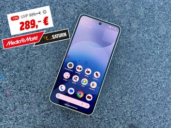 Das Nothing Phone (3a) liegt auf einem Steinboden und ein Angebot wird daneben angezeigt.