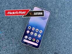 Nothing Phone 3a auf einem Tisch mit dem MediaMarkt und Saturn Logo