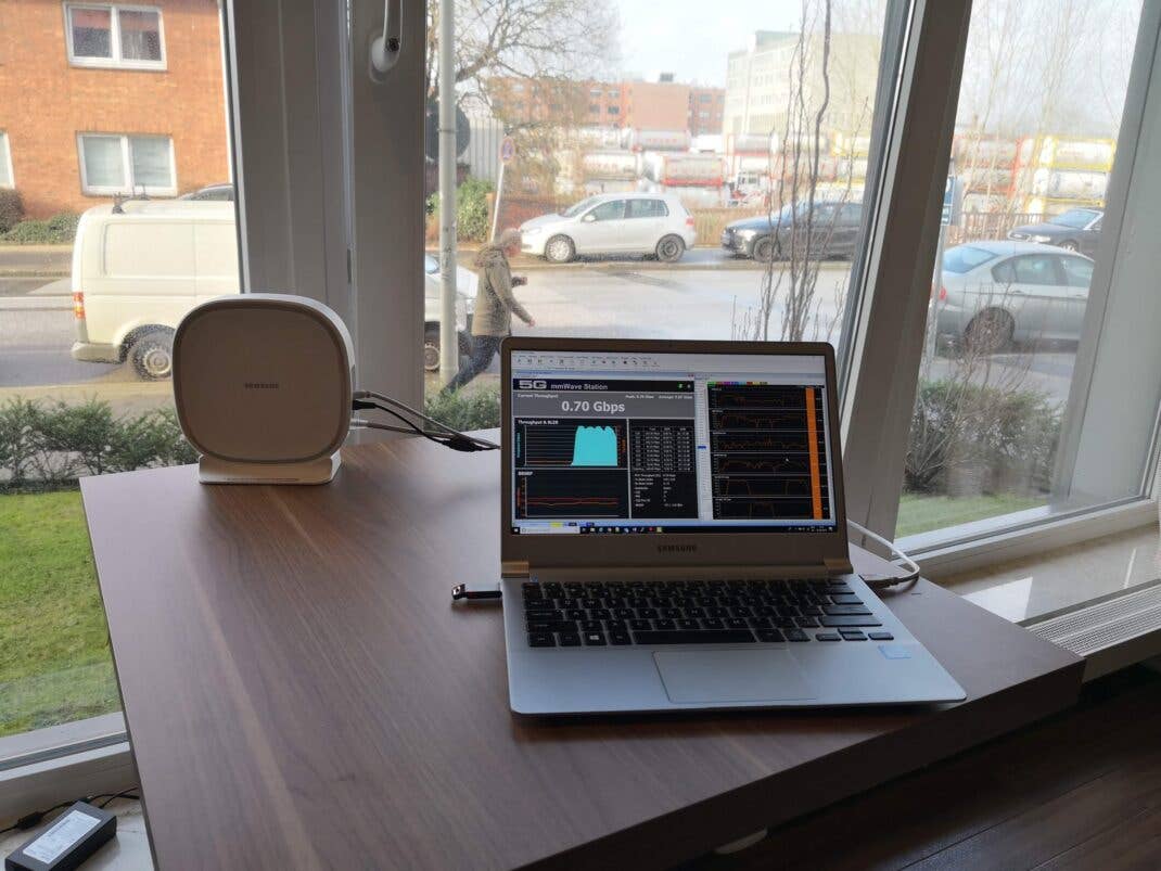 Eine Antenne und ein Laptop mit Speedtest stehen auf einem Tisch am Fenster