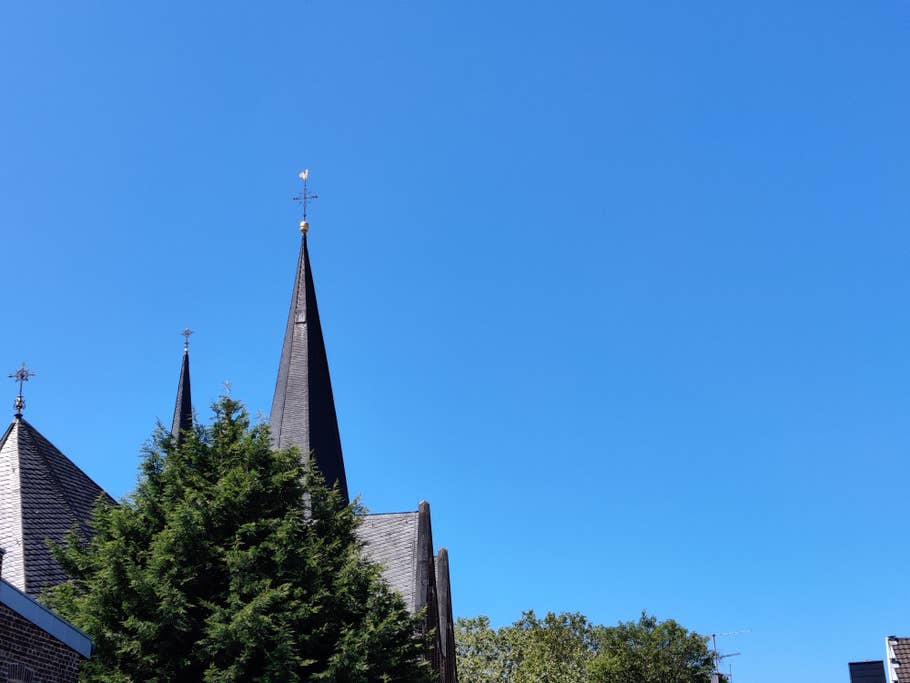 Kirchturm vor blauem Himmel mit zweifach Zoom