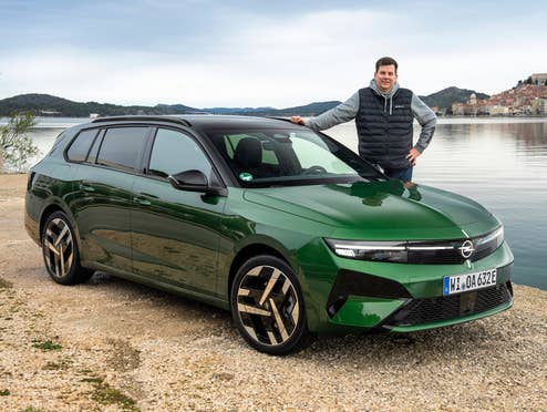Hayo Lücke neben dem Opel Astra Sports Tourer Electric.
