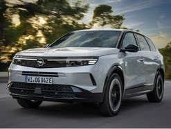 Opel Grandland Plug-in-Hybrid während der Fahrt auf der Straße in der Frontansicht.