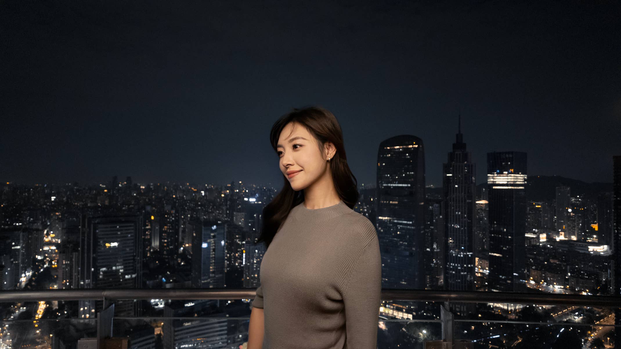 Foto einer Frau vor einer nächtlichen Skyline