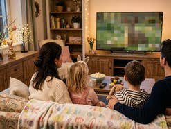 Familie sitzt an Ostern gemeinsam auf der Couch vor dem Fernseher