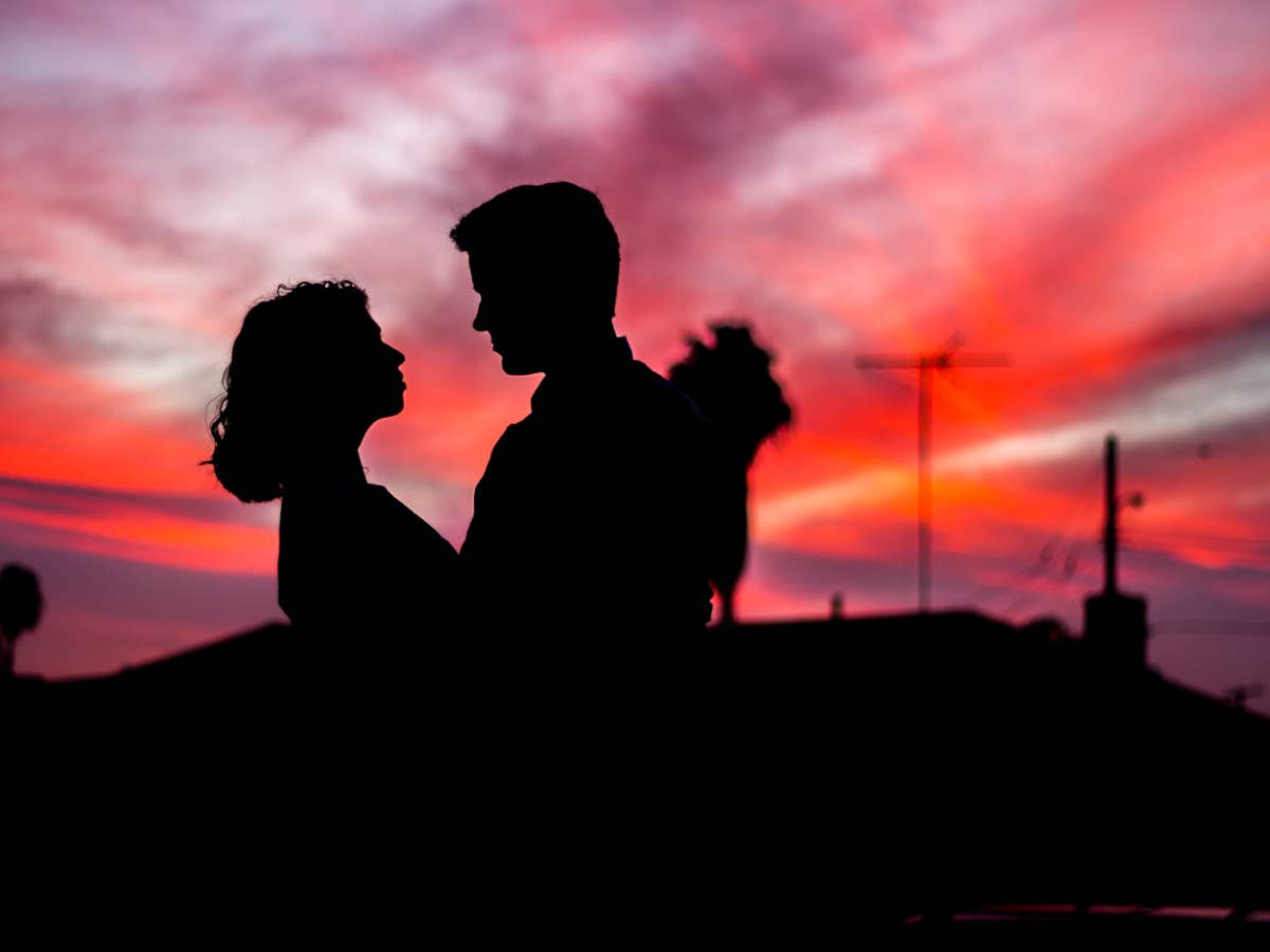 Silhouette eines Pärchens vor einem Sonnenuntergang.