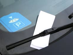 Parkscheibe liegt im Auto und davor ist ein Strafzettel